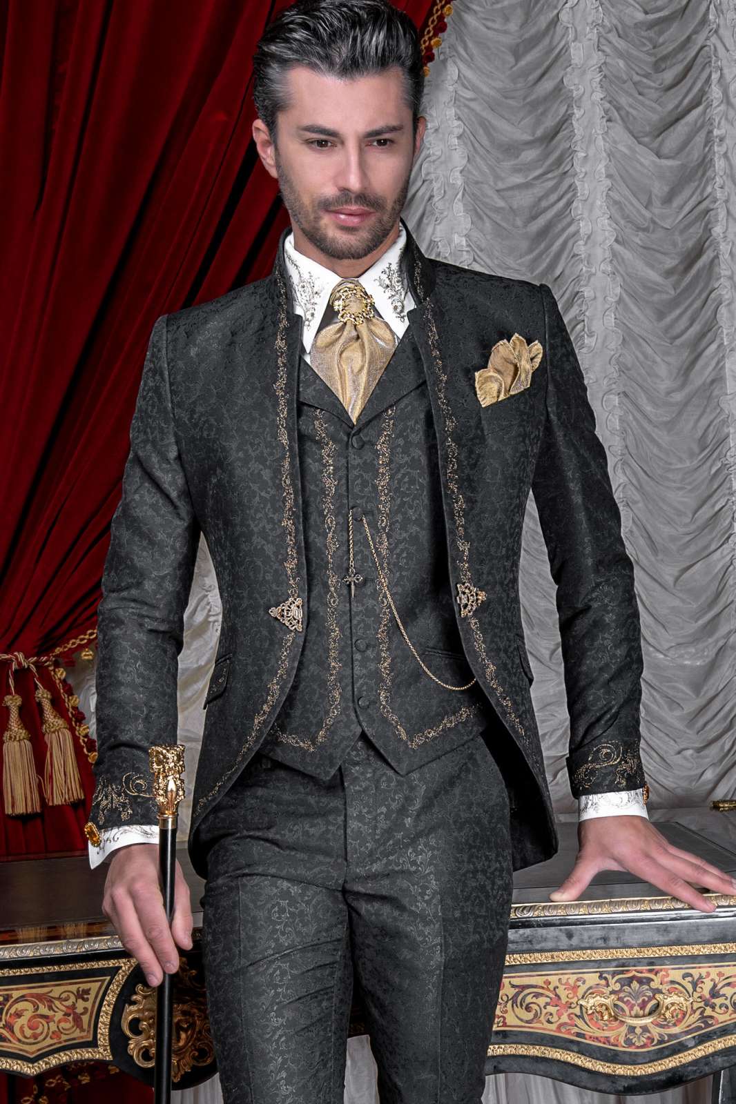 Traje de novio barroco, levita de época cuello mao en tejido jacquard negro con bordados dorados y broche de cristal. Traje de novio 2663 Mario Moyano